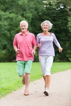 Active retired couple jogging in a park