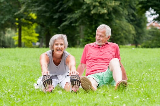 Active retired couple doing sports in a park