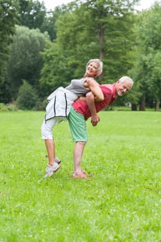 Active retired couple doing sports in a park