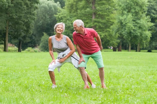 Active retired couple doing sports in a park