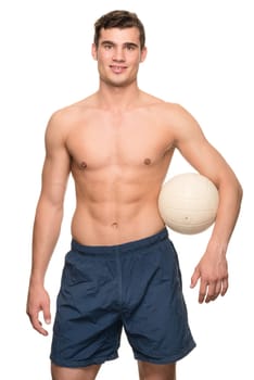 Young man with a volleyball in front of white studio background