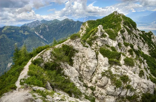 Narrow hiking trail leads over a ridge to the mountain summit