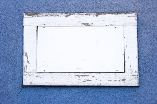 White wooden frame with white area as text box in a blue wall