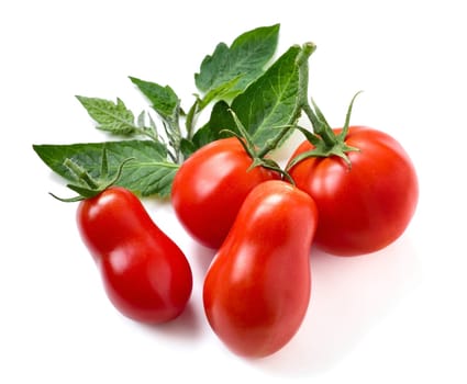 Four ripe tomatoes and leaves on white background