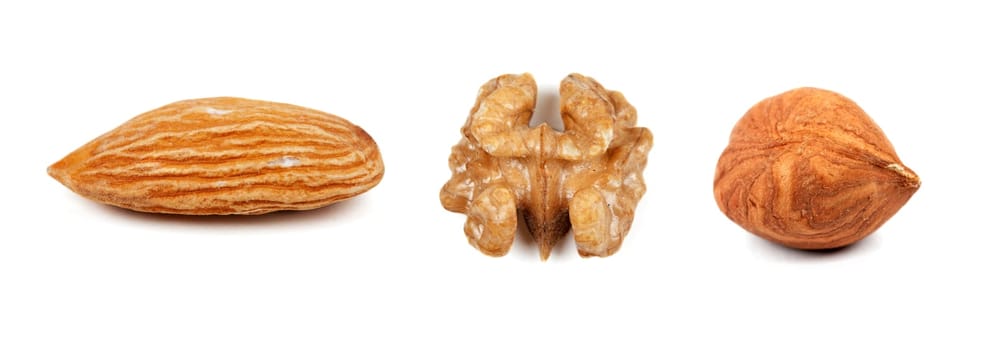 Collage of the three nuts, walnuts, hazelnuts, almonds, isolated on a white background. The image is composed of multiple photos
