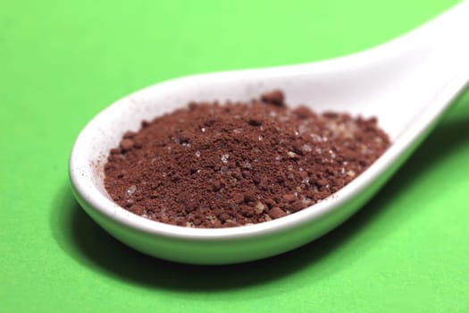 sugary cacao powder on a porcelain spoon