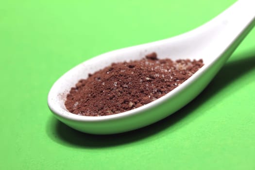 sugary cacao powder on a porcelain spoon