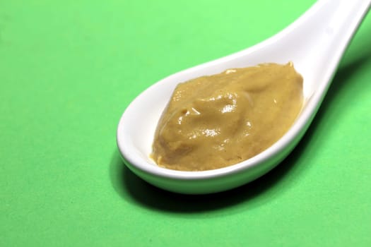 mustard on a porcelain spoon
