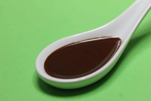 chocolate sauce on a porcelain spoon