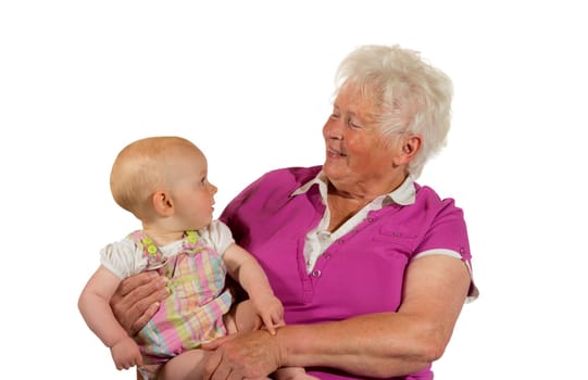 Trusting young baby cradled in its grandmother's arms looking up at her smiling face