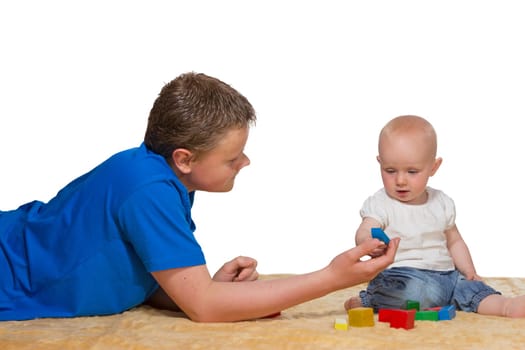 Father and baby playing happily together with colourful wooden building blocks on the floor as he teaches his child coordination