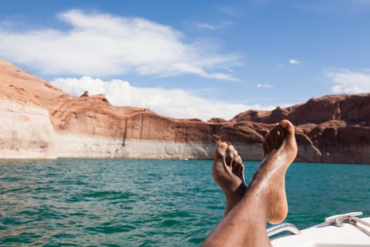 Feet of a relaxing man lying down on a boat
