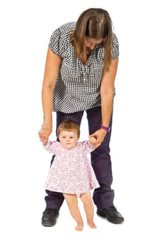 baby taking first steps with mother help on white background