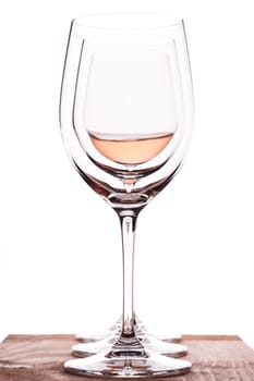 3 wine glasses and one of them with ros wine in the backlight