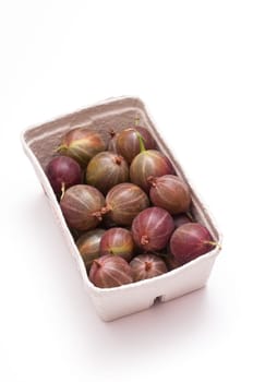 Ripe gooseberries in a cardboard box against a white background