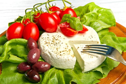 fresh cheese with salad, tomatoes and black olives