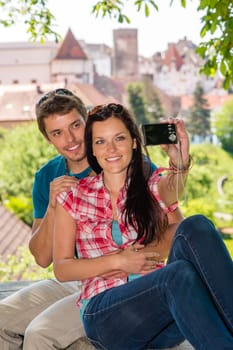 Happy young couple take photo of themselves smiling city tourists