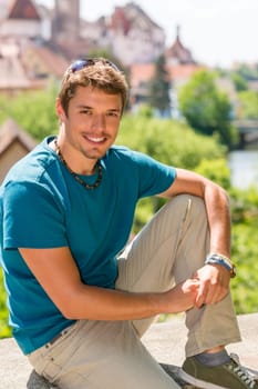 Young attractive man visit city sightseeing smiling posing sunny day