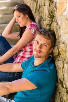 Young couple resting on stone stairs leisure time