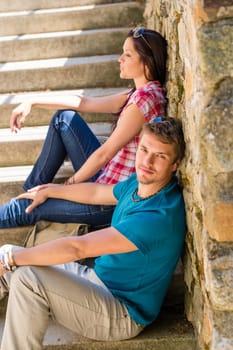 Young couple resting on stone stairs leisure time in city