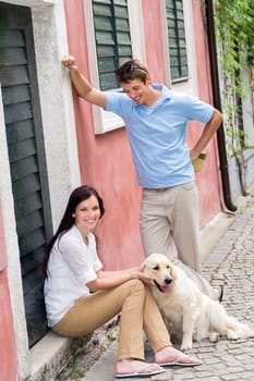 Happy couple resting with dog on street pet smiling love