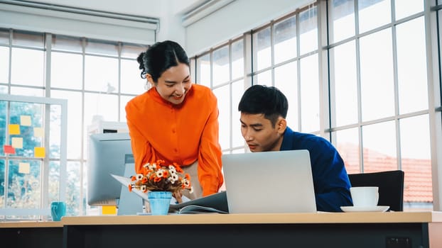 Two business people talk project strategy at office meeting room. Businessman discuss project planning with colleague at modern workplace while having conversation and advice on financial report. Jivy
