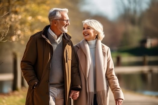 a happy, beautiful elderly couple strolling through the autumn park, talking to each other and laughing. Romance. the concept of a healthy lifestyle for the elderly.