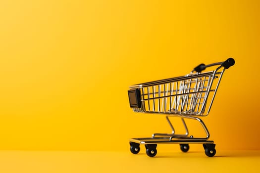 Small empty supermarket grocery push cart for shopping on yellow colourful trendy fashion background. Copy space. sales, discounts, purchases and consumer concept. Black friday