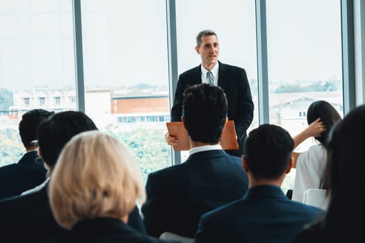 Group of business people meeting in a seminar conference . Audience listening to instructor in employee education training session . Office worker community summit forum with expert speaker . Jivy