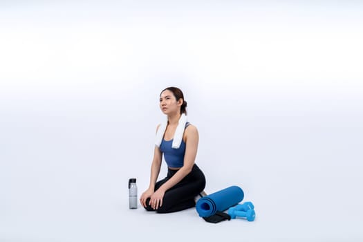 Athletic and sporty asian woman resting after intensive cardio workout training. Healthy exercising and fit body care lifestyle pursuit in studio shot isolated background. Vigorous