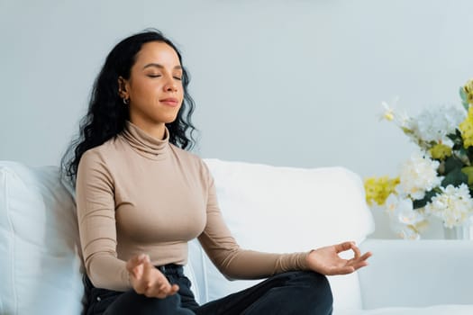 Young African American woman practice crucial mindful meditation at home living room for improving mental health strength and peaceful beautiful living