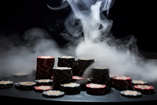 Gaming table with chips in clouds of cigarette smoke. Close-up. Gambling concept.