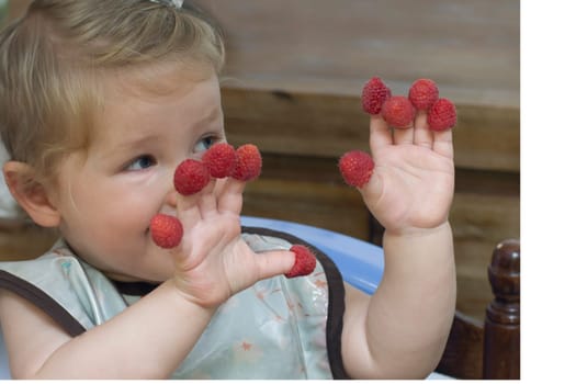 Little girl with raspberry on the fingers