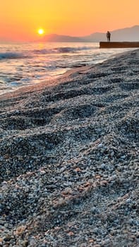 Landscape of beautiful seashore with sunset on background of sea, vertical frame