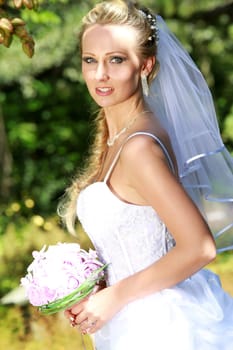 portrait of bride with bouquet in the park