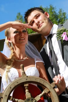 portrait of wedding couple with ship steering wheel
