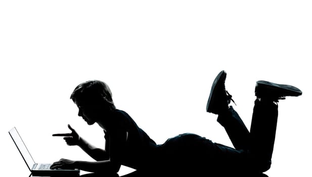 one caucasian young teenager silhouette boy girl computer computing laptop lying on front full length in studio cut out isolated on white background