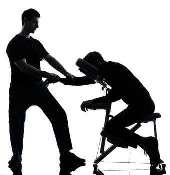 two men performing chair back massage in silhouette studio on white background