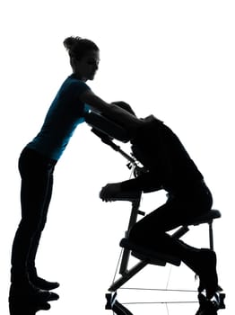 one man and woman perfoming chair massage in silhouette studio on white background