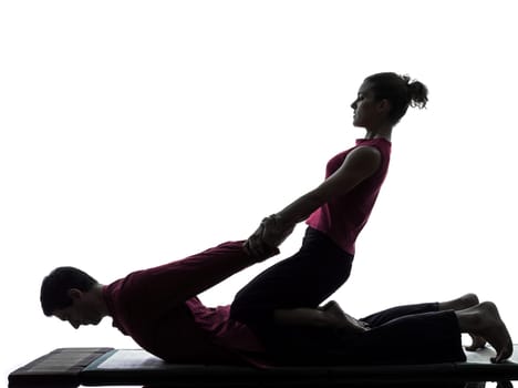 one man and woman perfoming thai massage in silhouette studio on white background