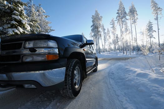 large car, suv, driving on a snowy country road, winter scenery from sweden