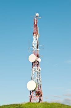 Communication tower on a grassy hill