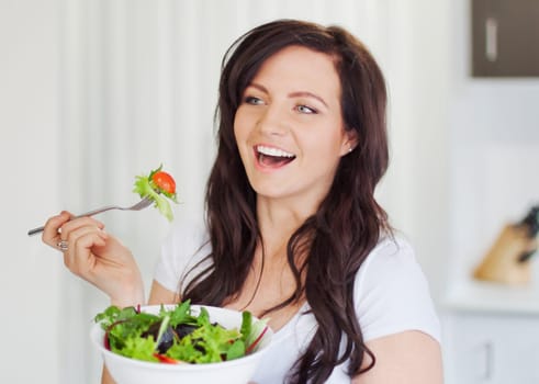 Attractive young woman eating a healthy salad
