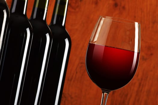 Composition with wineglass and bottles of red wine