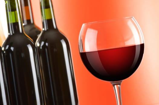 Composition with wineglass and bottles of red wine