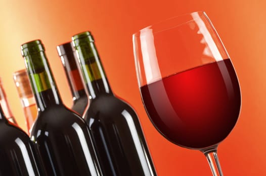 Composition with wineglass and bottles of red wine