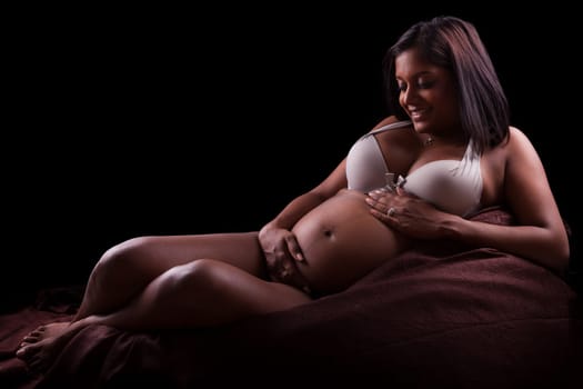 Young beautiful pregnant indian woman touching her belly