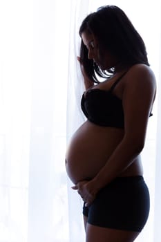 Young beautiful pregnant indian touching her tummy