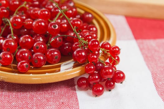 Berries of a red currant in a plate on a table