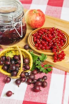 Jam with berries of red currant and gooseberry on the table